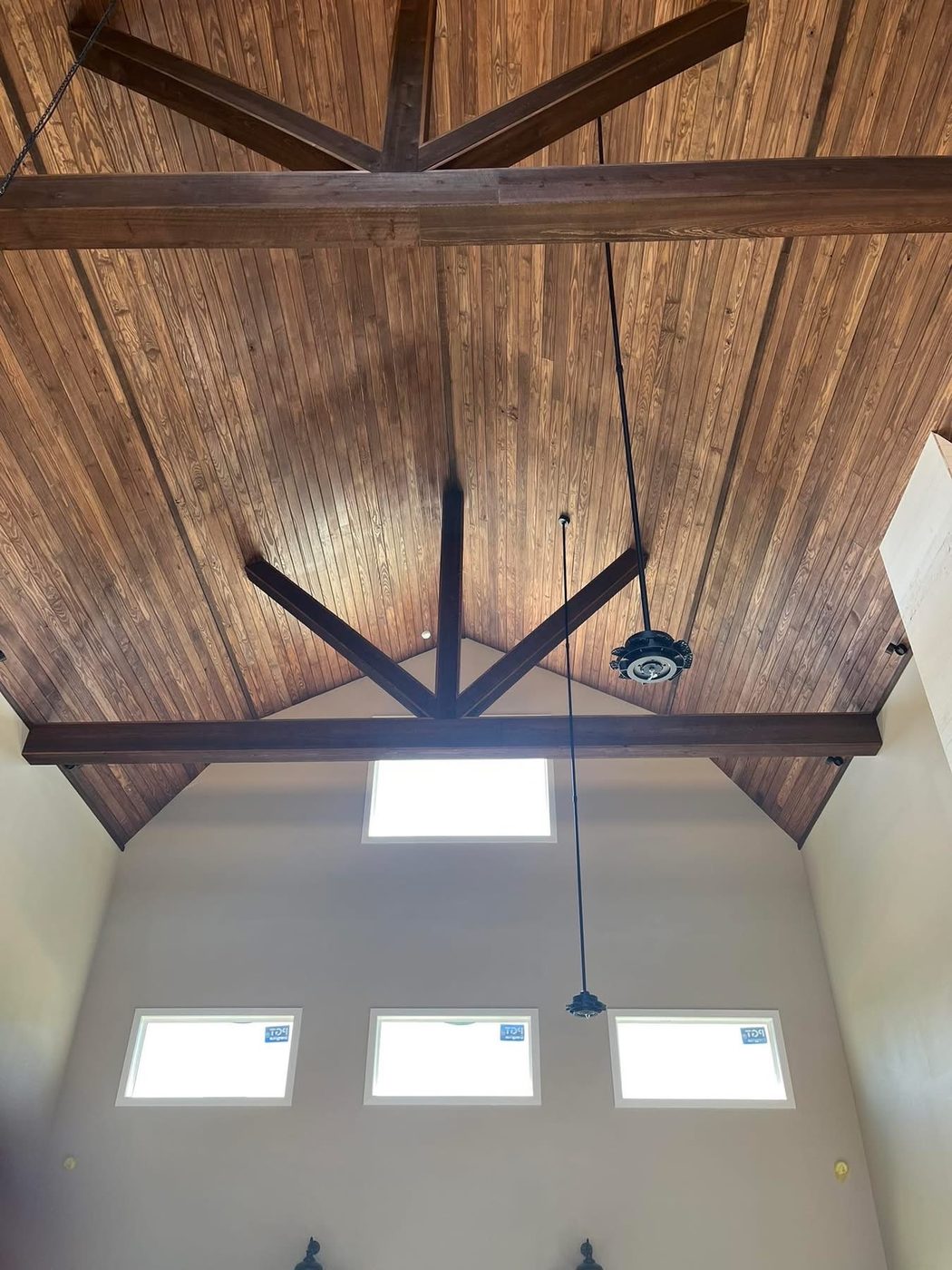 Vaulted wood-plank ceiling with dark beams and skylights